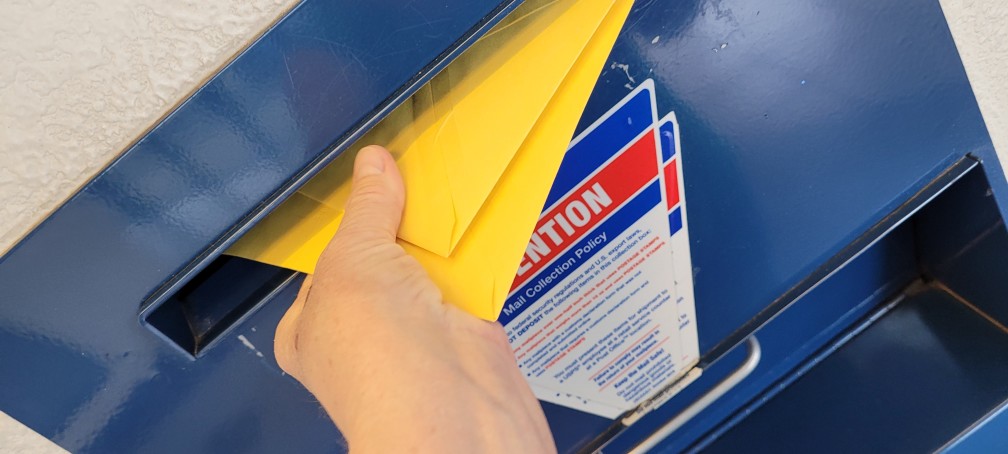 stuffing mail into a mailbox