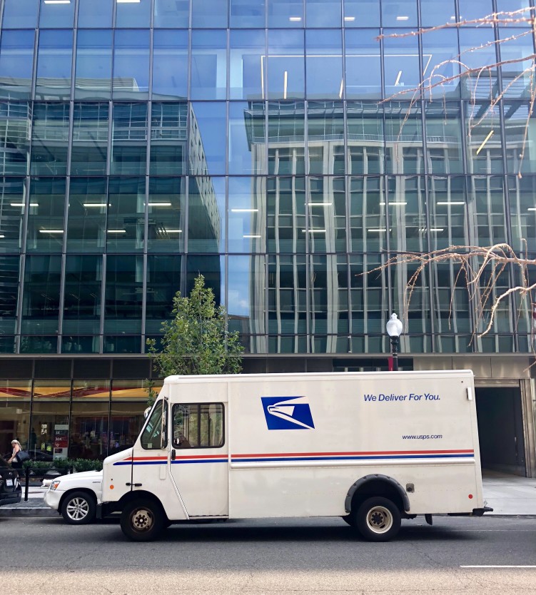 usps truck in front of a building